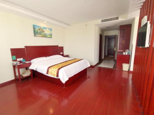 a bedroom with a large bed and a red floor at GreenTree Inn Jiangsu Suzhou Taicang Liuhe Passenger Station Express Hotel in Taicang