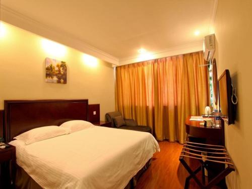 a bedroom with a bed and a desk and a window at GreenTree Inn Anhui Hefei Economic Development Zone Convention and Exhibition Center Business Hotel in Hefei