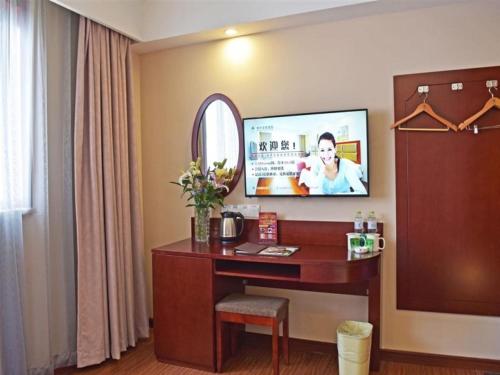 a hotel room with a desk and a mirror at GreenTree Inn JiangSu Changzhou Dinosaur Park Global Harbor Express Hotel in Changzhou