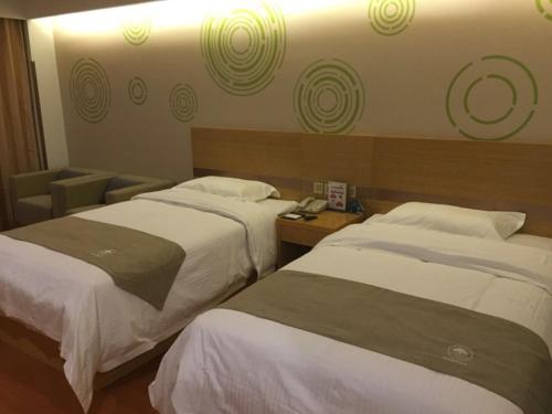 a hotel room with two beds and a telephone at GreenTree Inn Beijing Tongzhou District Yujiawu Technology park Express Hotel in Tongzhou