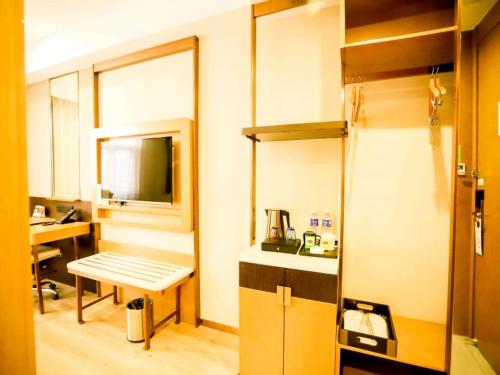 Cette chambre dispose d'une cuisine avec un banc et une table. dans l'établissement GreenTree Inn Xuzhou Economic Development Zone Da Miaozhen Business Hotel, à Xuzhou