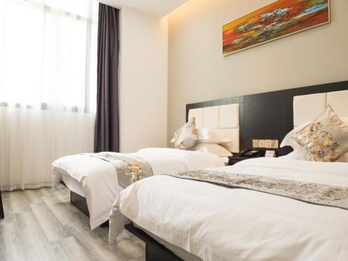 a hotel room with two beds and a window at Shell Wuxi Huishan DistrictWanda Plaza Yanqiao Subway Station Hotel in Wuxi