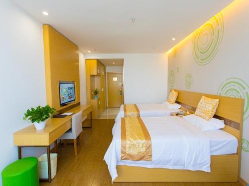 a hotel room with two beds and a desk at GreenTree Inn Cixi Zhouxiang Town Jiayue Plaza Business Hotel in Cixi
