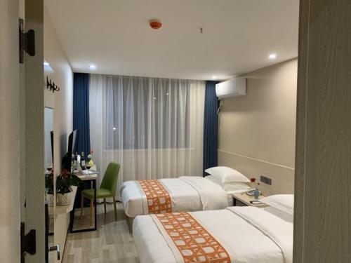 a hotel room with two beds and a desk at Shell Xi'an Yanta District Jixiang Village Subway Entrance Hotel in Xi'an