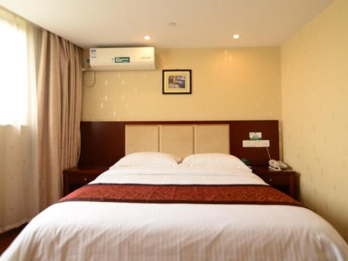 a bedroom with a large bed in a hotel room at GreenTree Inn JiangSu Suzhou Kunshan Huaqiao in Kunshan