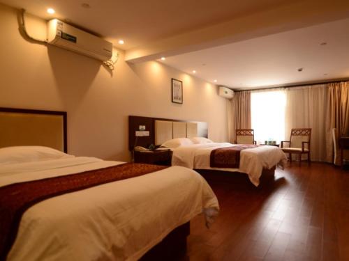 a hotel room with two beds and a air conditioner at GreenTree Inn JiangSu Suzhou Kunshan Huaqiao in Kunshan