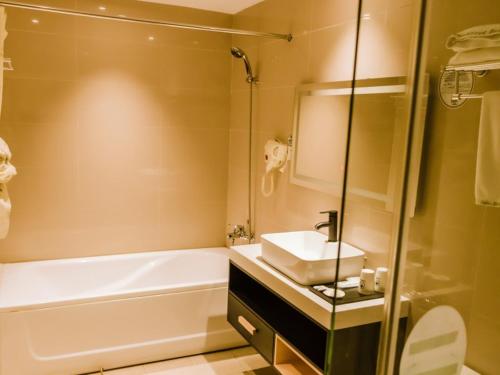 a bathroom with a sink and a bath tub and a sink at GreenTree Inn Anhui Xuancheng South Zhuangyuan Road Express Hotel in Xuanzhou