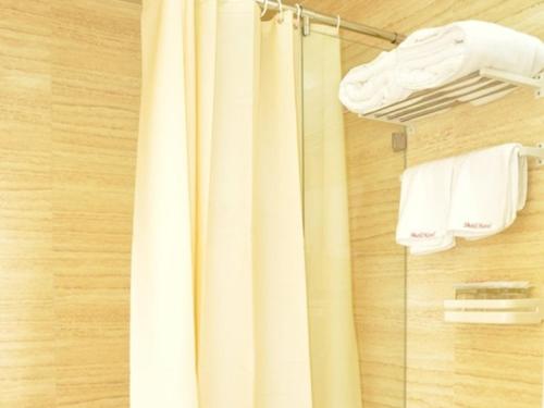 TianshuiにあるShell Tianshui Taian County Bus Station Hotelのシャワー(白いシャワーカーテン、タオル付)