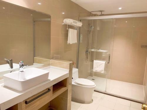 a bathroom with a sink and a toilet and a shower at GreenTree Inn Anhui Xuancheng South Zhuangyuan Road Express Hotel in Xuanzhou
