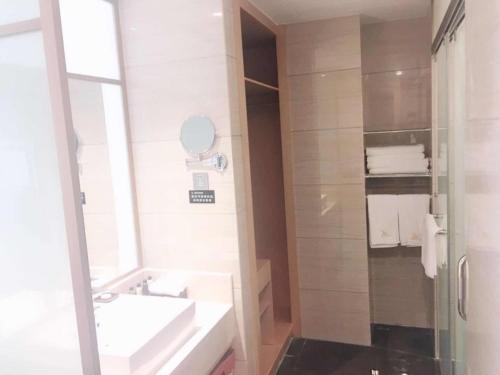 a white bathroom with a sink and a mirror at GreenTree Eastern Fuyang Yingdong District South Guoyang Road Hotel in Fuyang