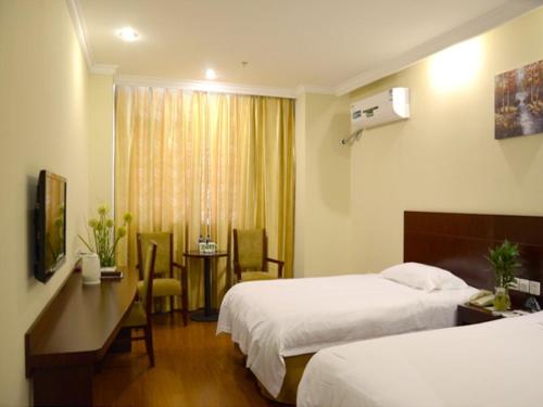 a hotel room with two beds and a desk at GreenTree Inn Jiangsu Nantong Rugao Haiyang Road Tiancheng Business Hotel in Rugao