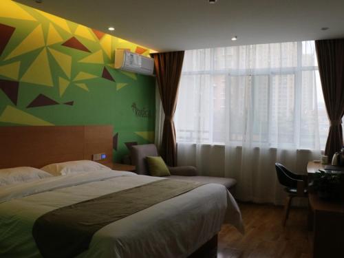 um quarto com uma cama e uma parede colorida em Vatica Hefei West Anqing Nongda East Gate Hotel em Hefei