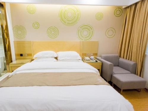a bedroom with a large bed and a chair at GreenTree Inn Maanshan East Railway Station Oushang Supermarket Business Hotel in Fengqiao