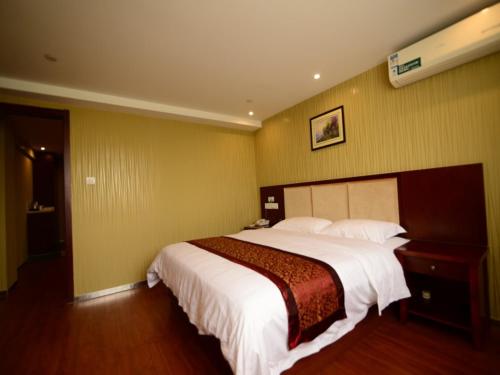 a bedroom with a large bed in a room at GreenTree Inn JiangSu Suzhou Kunshan Huaqiao in Kunshan