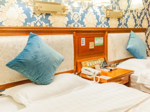 a hotel room with two beds and a phone at GreenTree Inn Nanning Xiuxiang Branch in Nanning