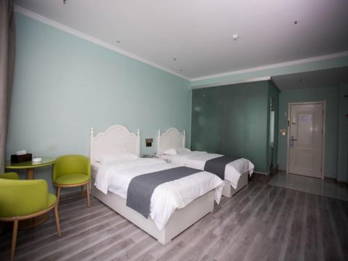 a bedroom with two beds and a table and chairs at Shell Chuzhou North Bus Station Hotel in Chuzhou