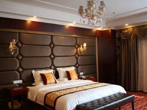 a bedroom with a large bed with a large headboard at GreenTree Inn Jiangsu Suqian Xiangwang Guli South Xingfu Road Business Hotel in Suqian