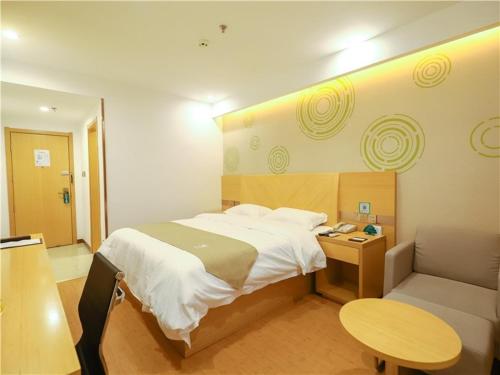1 dormitorio con cama, mesa y sofá en GreenTree Inn Yichun Development Zone Bus Terminal Express Hotel, en Yichun