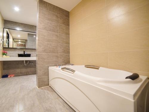 a bathroom with a white tub in a room at GreenTree Alliance Kunming Beijing Road Linyuqiao Subway Station Hotel in Kunming