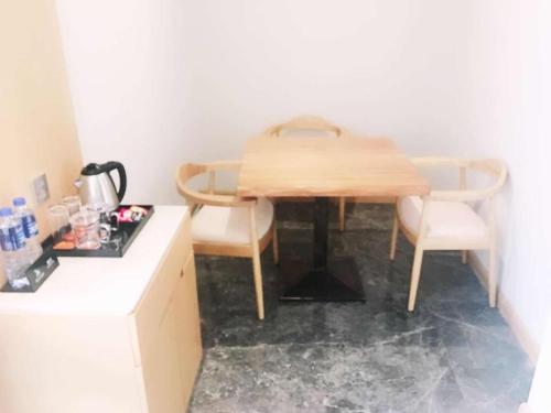 a kitchen with a wooden table and two chairs at GreenTree Eastern Fuyang Yingdong District South Guoyang Road Hotel in Fuyang