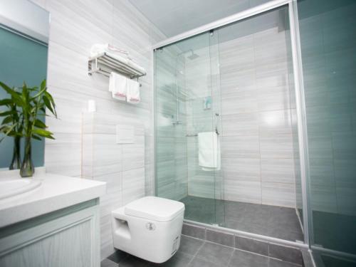 a bathroom with a toilet and a glass shower at Shell Chuzhou North Bus Station Hotel in Chuzhou