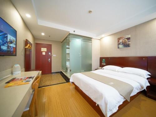 a large bedroom with a large bed and a desk at GreenTree Inn Shanghai Baoshan Yanghang Shuichan Road Hotel in Baoshan