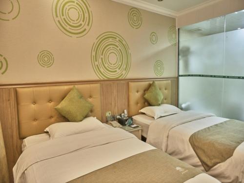 a hotel room with two beds and a window at GreenTree Inn Guangdong Foshan Longjiang North Fenghua Road Express Hotel in Shunde