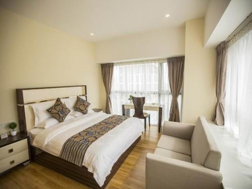 a bedroom with a large bed and a couch at GreenTree Alliance Dali Xiaguan Area Jianshe Road Tai'an Metro Hotel in Dali