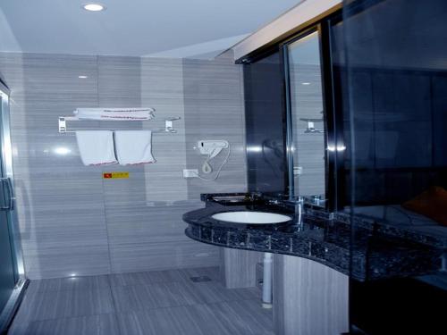a bathroom with a sink and a shower at Shell Anqing City Yingjiang District Renmin Road Pedestrian Street Hotel in Anqing