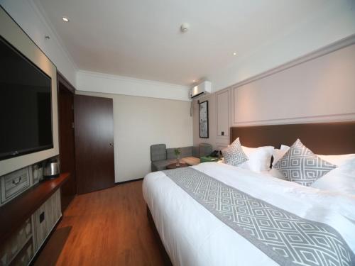 a hotel room with a large bed and a flat screen tv at GMA Hotel ShangHai WuNing Road ZhenPing Road Metro Station in Shanghai