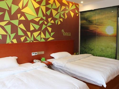 two beds sitting next to each other in a room at Vatica Fuyang Linquan County Tenghui International City Hotel in Fuyang