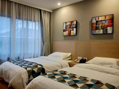 a hotel room with two beds and a window at Shell Shanghai New International Expo Center Fanghua Road Metro Station Hotel in Shanghai