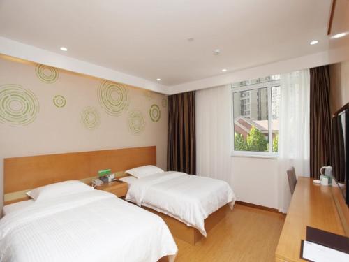 um quarto de hotel com duas camas e uma janela em GreenTree Inn Hefei Huainan Road Huaihe Garden Express Hotel em Hefei
