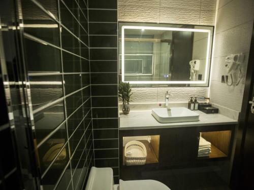 y baño con lavabo y espejo. en Shell Fuyang City South Bus Station Hotel, en Fuyang