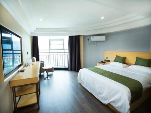 um quarto de hotel com uma cama grande e uma secretária em GreenTree Inn Shandong Linyi Bus Station Express Hotel em Linyi