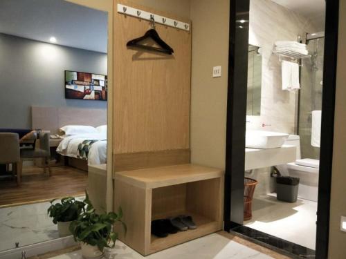 a bathroom with a shower and a bedroom with a bed at Shell Shanghai New International Expo Center Fanghua Road Metro Station Hotel in Shanghai