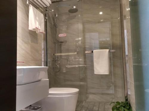 a bathroom with a shower and a toilet and a sink at Shell Shanghai New International Expo Center Fanghua Road Metro Station Hotel in Shanghai
