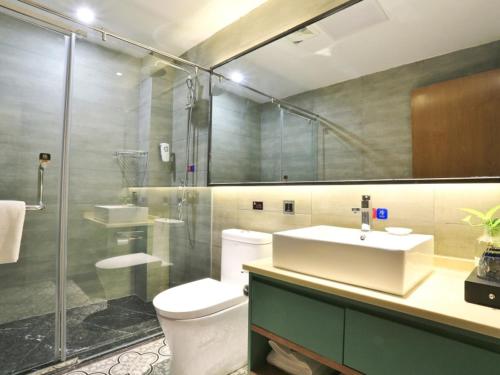 a bathroom with a toilet and a sink and a shower at GME Rizhao Jinan Road Sun Plaza Hotel in Rizhao
