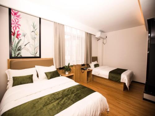 um quarto de hotel com duas camas e uma janela em GreenTree Inn Qingdao Huangdao District Jinshatan Road Jinshatan Hotel em Beizhuang