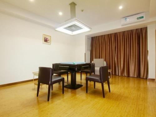 a room with a piano and chairs and a table at GreenTree Inn Zhejiang Jiaxing Xiuzhou District Wangjiangjin Town Business Hotel in Jiaxing