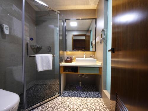 a bathroom with a sink and a shower at GME Hefei Feidong county High Speed Railway Station Longquan East Road Hotel in Hefei