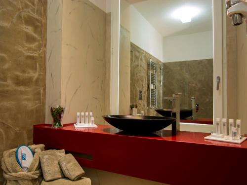 uma casa de banho com um lavatório preto num balcão vermelho em Partenope Relais em Nápoles