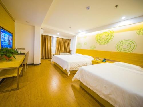 a hotel room with two beds and a television at GreenTree Inn Chuzhou Langya Mountain Scenic Area Xijian Road Business Hotel in Chuzhou