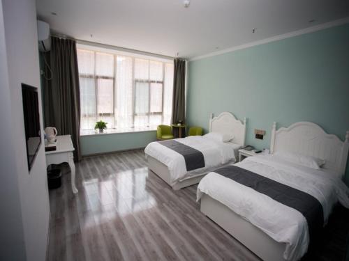 a hotel room with two beds and a window at Shell Chuzhou North Bus Station Hotel in Chuzhou