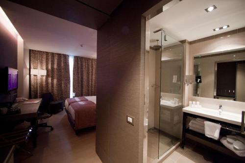 a hotel room with a large bed and a large mirror at Crowne Plaza Verona Fiera, an IHG Hotel in Verona