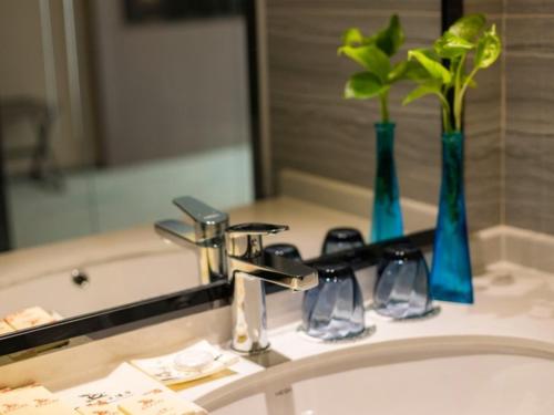 a bathroom sink with a faucet and a mirror at GreenTree Eastern Wuxi Xinwu District Airport Road Hotel in Wuxi