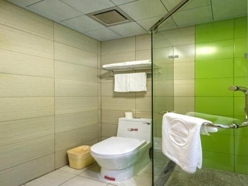 a bathroom with a toilet and a glass shower at GreenTree Inn Anshun Xihang Road Business Hotel in Anshun
