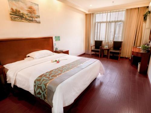 a hotel room with a large bed and a desk at Greentree Inn Mozitan Road Yiwu Small Commodities Wholesale City in Lu'an