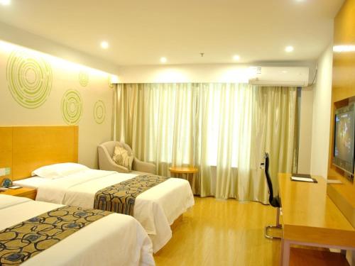 池州市にあるGreenTree Inn Chizhou High-Speed Railway Station Hotelのベッド2台とテレビが備わるホテルルームです。