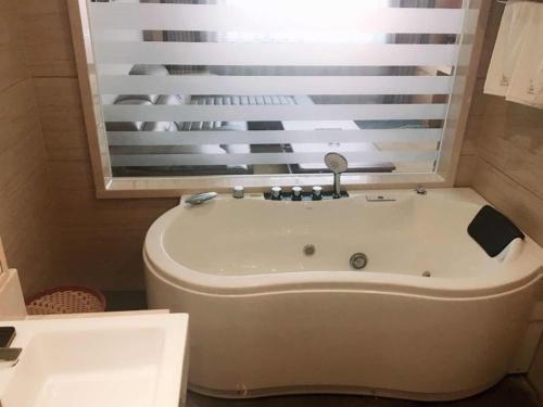 a bath tub in a bathroom with a window at GreenTree Eastern Fuyang Yingdong District South Guoyang Road Hotel in Fuyang